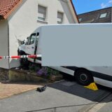 Ein die Straße hinabrollender Pakettransporter wurde durch eine Hauswand gestoppt.