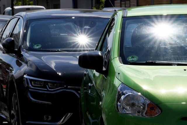 Sonne scheint auf parkende Autos.