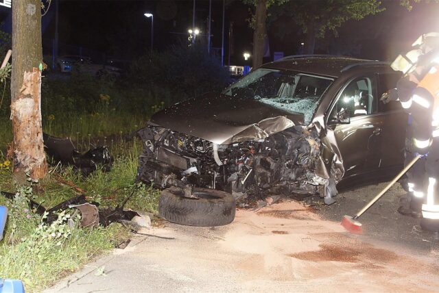 Ein demoliertes Auto steht vor einem Baum auf der Industriestraße in Bergkamen.