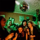 Eine Gruppe Menschen singt zusammen Karaoke.
