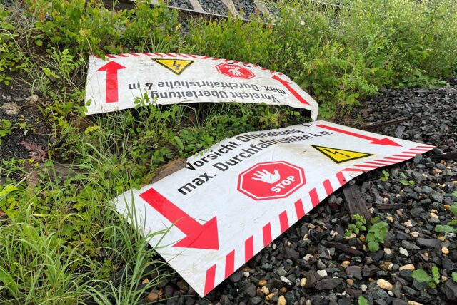 Zwei Warnschilder liegen auf dem Boden.