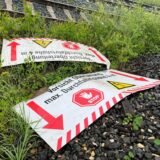Zwei Warnschilder liegen auf dem Boden.