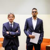 Jérôme Boateng (rechts) hält Unterlagen in der Hand und steht im Gerichtssaal neben seinem Rechtsanwalt Leonard Walischewski (links)