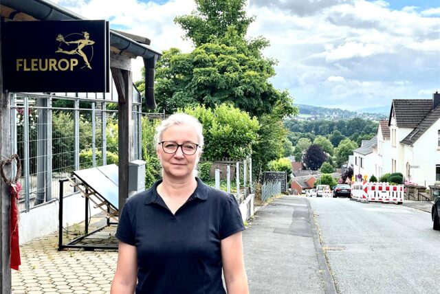 Sonja Dickel vor ihrem Blumengeschäft und den Baustellenabsperrungen an der Friedhofstraße.