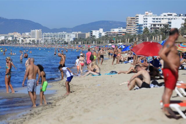 Menschen schwimmen und sonnenbaden am Strand von Arenal auf Mallorca am ersten Oktoberwochenende mit Temperaturen von 30 Grad.