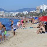 Menschen schwimmen und sonnenbaden am Strand von Arenal auf Mallorca am ersten Oktoberwochenende mit Temperaturen von 30 Grad.