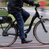 Ein Radfahrer auf einem Pedelec. Es sind nur der Unterkörper und die Beine zu sehen.