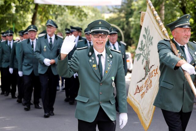 Schützenbrüder vom Schützenverein Kirchspiel Bausenhagen marschieren beim großen Festumzug durch das Dorf