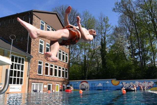 Im Freibad Bornekamp in Unna springt ein Mann mit Badehose ins Wasser