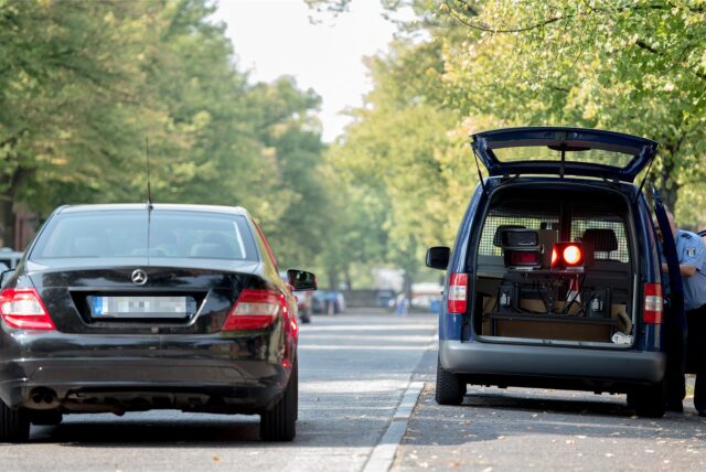 Ein Radarwagen blitzt einen vorbeifahrenden Pkw.