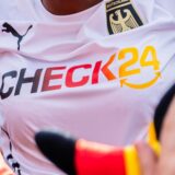 Jubelnde Fußballfans in Deutschland-Fankleidung.