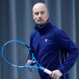 Tennisspieler Andreas Thiveßen mit Schläger und Ball in der Tennishalle.