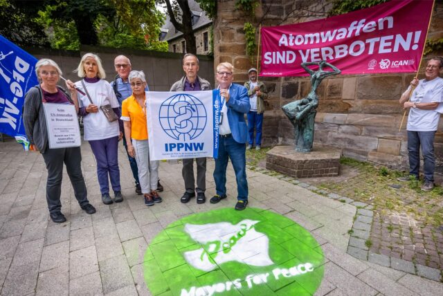 V.l. an der Fahne Dr Juergen Huesmann IPPNW, andere Seite vom Plakat Dr Martin Rees IPPNW, davor Bürgermeister Norbert Schilff, Dr Johannes Koepchen IPPNW mit Yoko Schluetermann von der Deutsch Japanischen Gesellschaft sowie Beteiligten der Aktion.