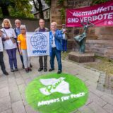 V.l. an der Fahne Dr Juergen Huesmann IPPNW, andere Seite vom Plakat Dr Martin Rees IPPNW, davor Bürgermeister Norbert Schilff, Dr Johannes Koepchen IPPNW mit Yoko Schluetermann von der Deutsch Japanischen Gesellschaft sowie Beteiligten der Aktion.