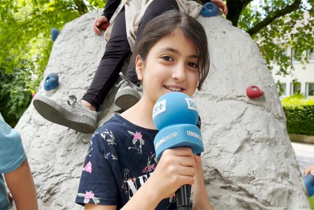 Yostina (10) vom DRK-Familienzentrum in Schwerte steht auf dem neuen Spielplatz an der Rohrmeisterei. Sie spricht in das Mikrofon der Ruhr Nachrichten.