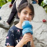 Yostina (10) vom DRK-Familienzentrum in Schwerte steht auf dem neuen Spielplatz an der Rohrmeisterei. Sie spricht in das Mikrofon der Ruhr Nachrichten.