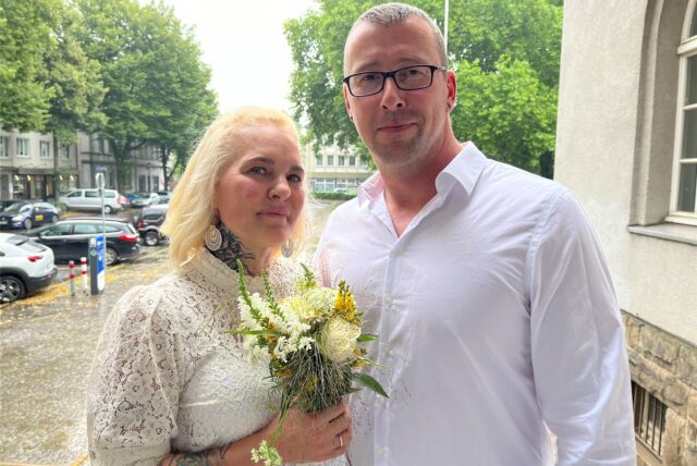 Jenny und Markus Riebe stehen frisch getraut am Rathaus in Schwerte.