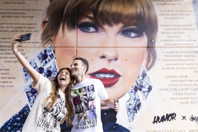 Giorgia Zampetti (l) und Tommaso Zampetti, Taylor Swift-Fans aus Italien, fotografieren sich vor einem neuen Wandgemälde, das zusammen mit den Swiftie Steps im Wembley Park enthüllt wurde, während der Weltstar ihre erste Londoner Show startet.