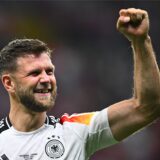 Niclas Füllkrug jubelt und streckt den linken Arm in die Luft.