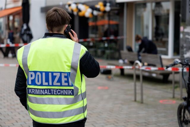 Eine Polizeibeamtin der Kriminaltechnik steht an einem abgesperrten Tatort.