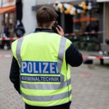 Eine Polizeibeamtin der Kriminaltechnik steht an einem abgesperrten Tatort.