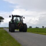  Ein Landwirt fährt mit seinem Trecker über einem Wirtschaftsweg.