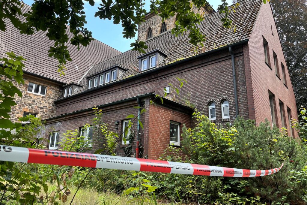 Kirchengebäude aus roten Backsteinen hinter rotweißem Flatterband.