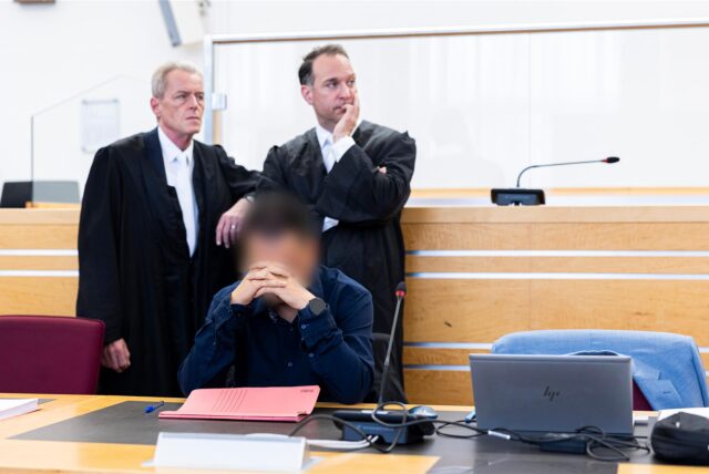 Der männliche Angeklagte (vorne) sitzt vor Verhandlungsbeginn in einem Gerichtssaal im Landgericht Hannover und stützt seinen Kopf. Dahinter stehen seine Anwälte Helmut Wöhler (l.) und Iyad Nassif (M.).