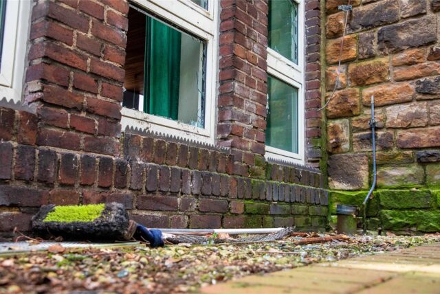 Vor einem zerborstenen Glasfenster der Christuskirche in Herten liegt nach einem Unfall ein Besen auf dem Boden.