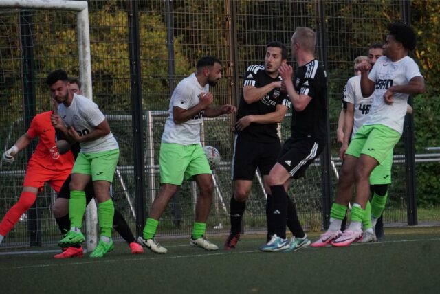 Spieler im Strafraum bei einer Ecke, alle drehen sich weg.