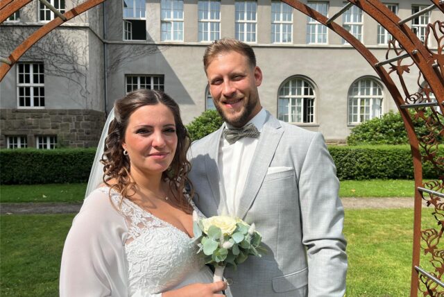 Saskia Wallender und Malte Iggena stehen vor dem Bogen am Rathaus in Schwerte.