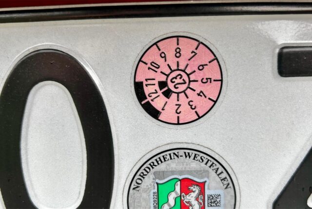 Ein Kennzeichen mit Tüv-Plakette.