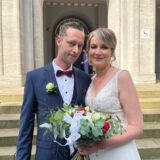 Svea und David Anders stehen frisch verheiratet vor dem Rathaus in Schwerte.