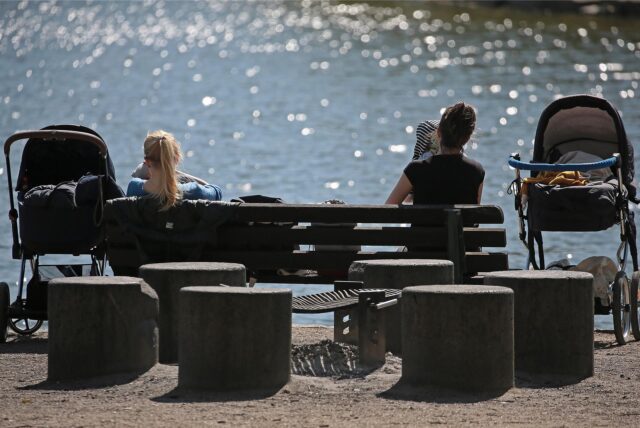 Zwei Frauen mit Kindern am Strand.
