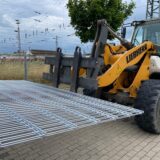 Ein Fahrzeug transportiert Zaunelemente.