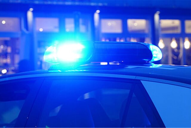 Ein Streifenwagen der Polizei steht mit eingeschaltetem Blaulicht an einem Einsatzort.