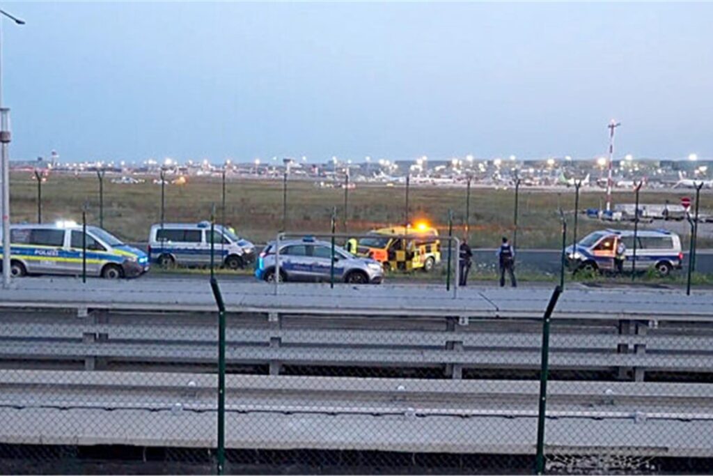 Einsatzfahrzeuge der Polizei stehen unweit des Rollfelds am Frankfurter Flughafen. Einsatzfahrzeuge der Polizei stehen unweit des Rollfelds am Frankfurter Flughafen.