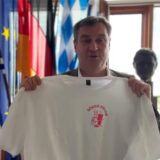Bayerns Ministerpräsident Markus Söder hält ein T-shirt mit dem Aufdruck «Söder Kebab» in die Kamera.