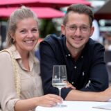 Eine Frau und ein Mann trinken beim Weinfest in Dortmund ein Glas Weißwein.