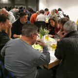 Menschen sitzen beim Kneipenquiz in Werne in Gruppen zusammen.
