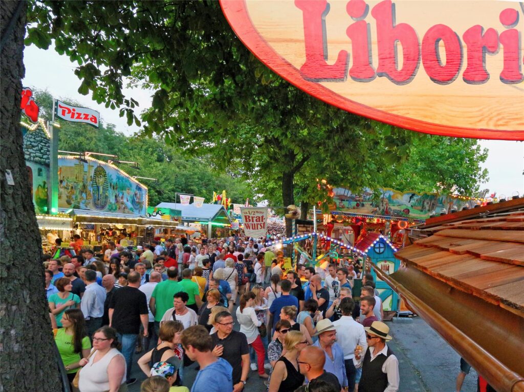 Kirmesbesucher gehen auf der Libori-Kirmes in Paderborn an Buden vorbei. Kirmesbesucher gehen auf der Libori-Kirmes in Paderborn an Buden vorbei.