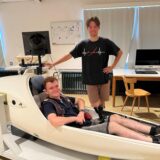Alexander Konschak und Lars Rothholz vom LSV Ruhr-Lenne Iserlohn: Alexander sitzt im Flugsimulator, Lars steht daneben.