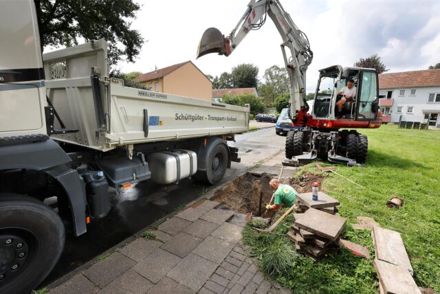 Ein Bagger hebt ein Loch in der Bachstraße in Bergkamen aus, um an Versorgungsleitungen zu kommen.