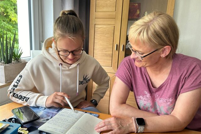Stefanie Tietz und Sandra Stein schauen in ein Notizbuch.