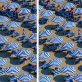 Suchbild mit Strandmotiv. Sonnenschirme und Liegen am Strand.