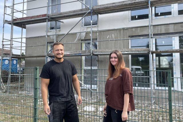 Hausverwalterin Jill Aschrich und Bauleiter Etnik Asani stehen vor einem der drei Neubauten im Dortmunder Westen. Vermietungsbeginn ist am 1. Dezember 2024.