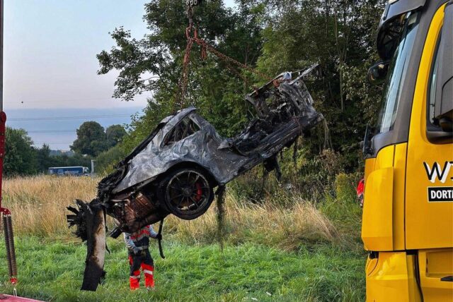 Zu sehen ist ein verbrannter Porsche, der von einme LKW angehoben wird.