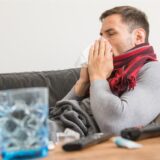Mann auf Sofa mit Erkältung