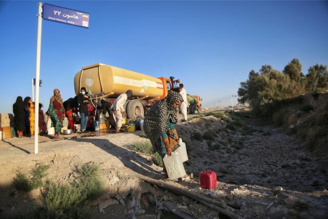Das undatierte Bild, aufgenommen im Mai 2023, zeigt, wie Bewohner nahe des ausgetrockneten Hamun-Sees Wasser von einem Tankwagen holen.