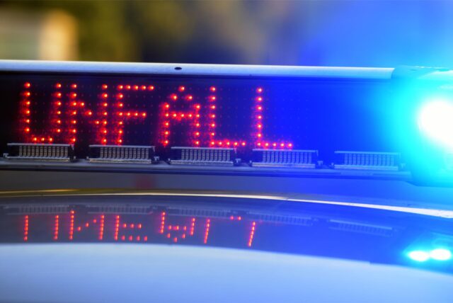 Rote Leuchtschrift „Unfall“ auf einem Polizeiwagen.